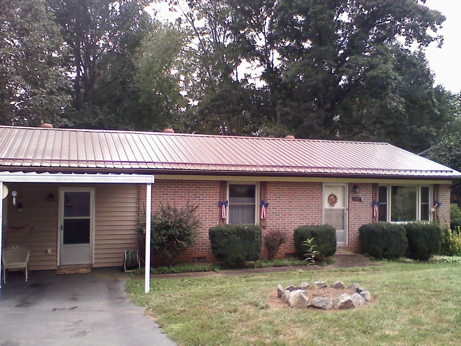 Bronze metal roof and carport on a brick ranch home — Roof Repair work by our crew in Homer